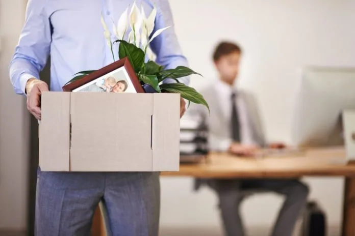 Trabajador saliendo de la oficina con una caja con sus pertenencias